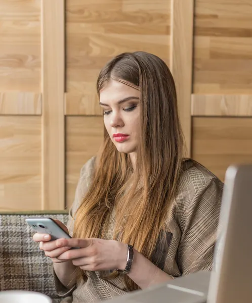 Profesional planificando una estrategia de publicidad en redes sociales con móvil y portátil